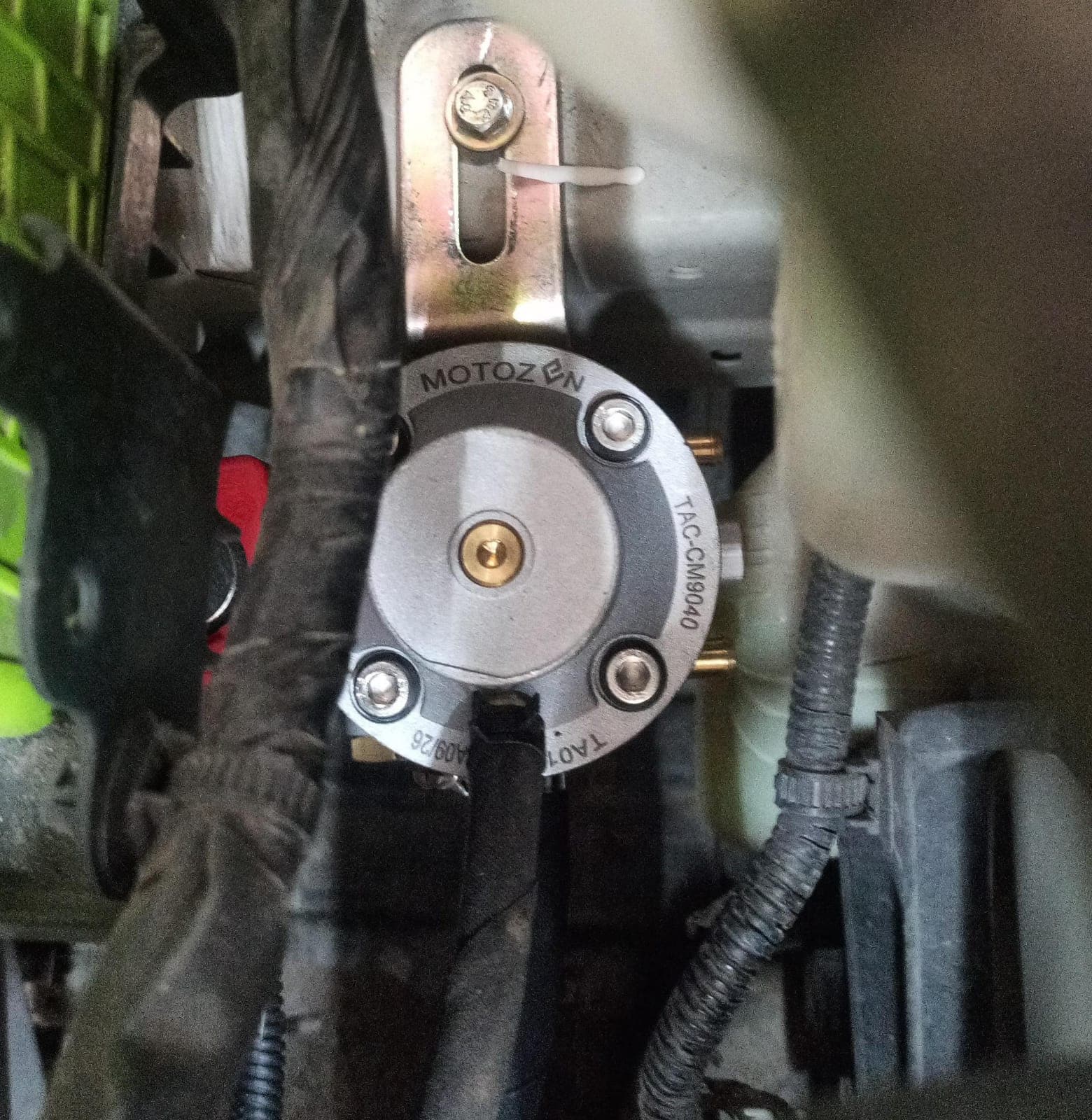 Pressure regulator mounted on a bracket in an engine bay