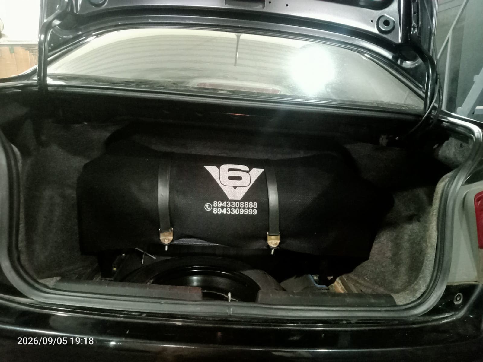 Boot-mounted CNG cylinder under a V6 cover in a sedan