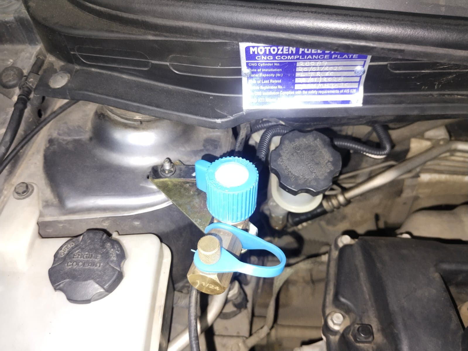 CNG filling valve in an engine bay, below the CNG compliance plate