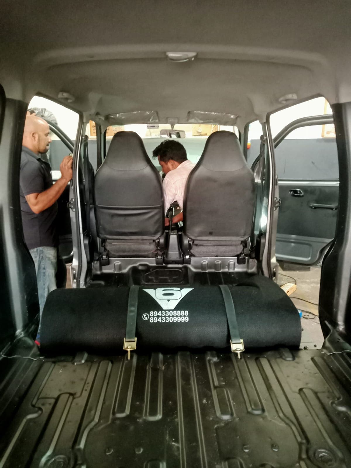Technicians at work on a van with a covered CNG cylinder fitted behind the front seats